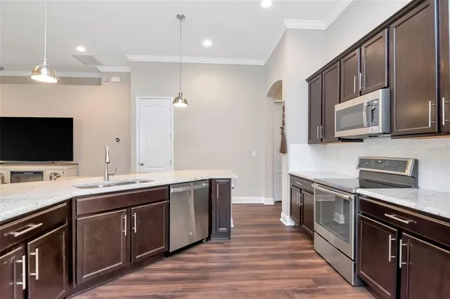a kitchen with stainless steel appliances a stove sink microwave and cabinets