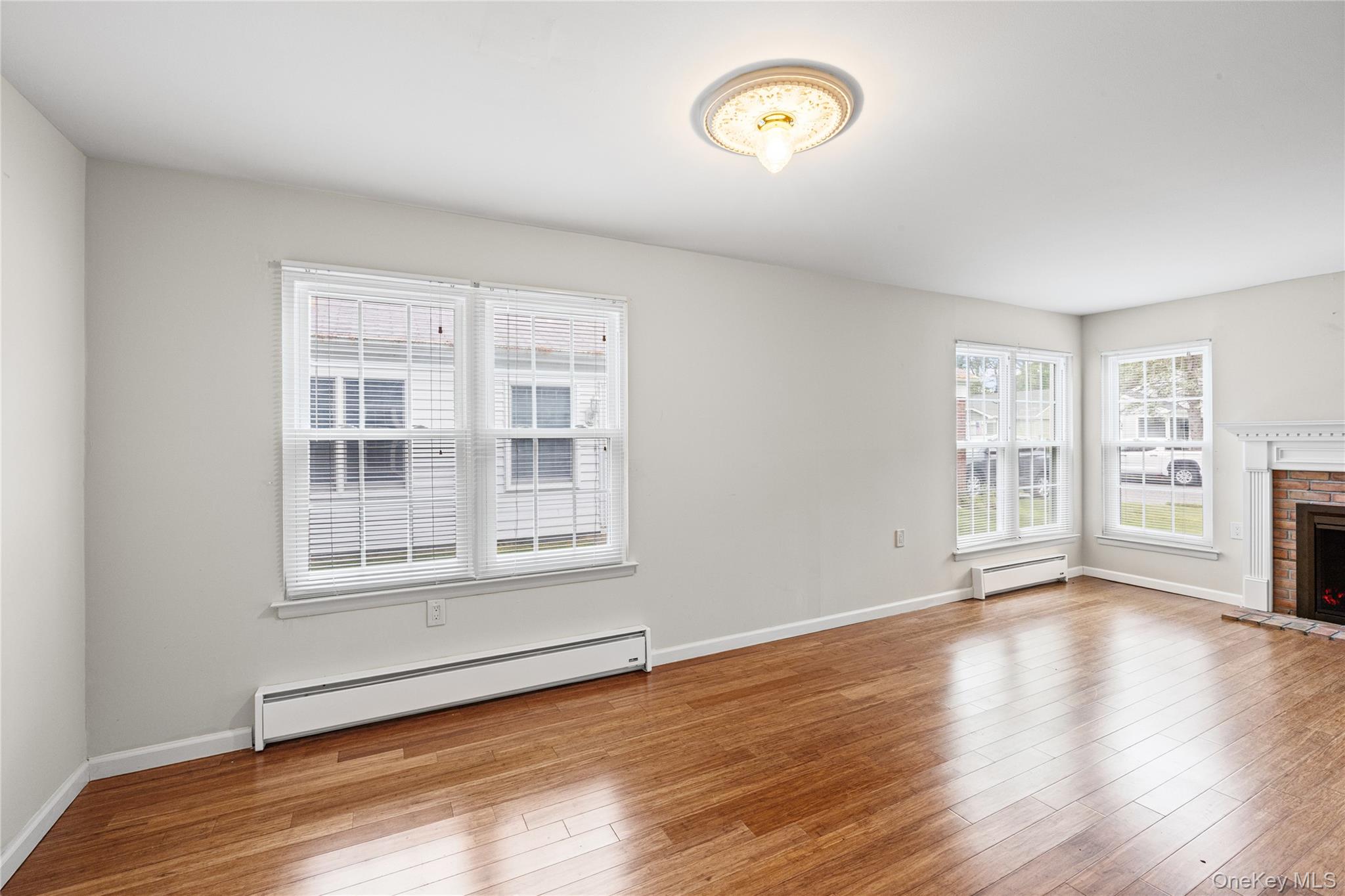 220 Belfast Lane Ridge, NY 11961 - Photo 16 of 44 a view of an empty room with wooden floor and a window