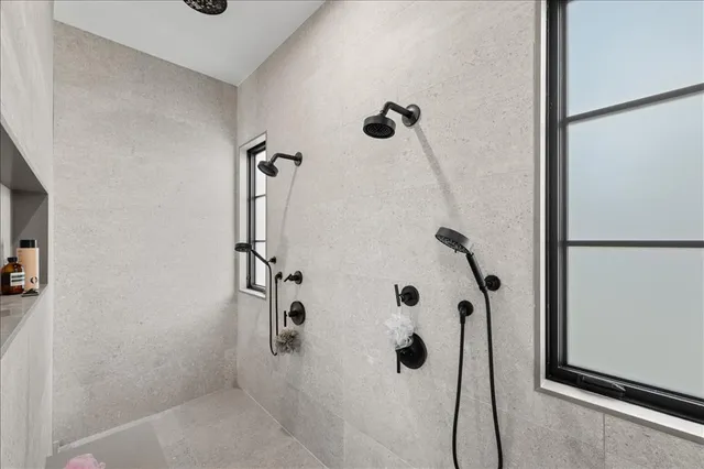 a spacious bathroom with a double vanity sink a large mirror and a bathtub