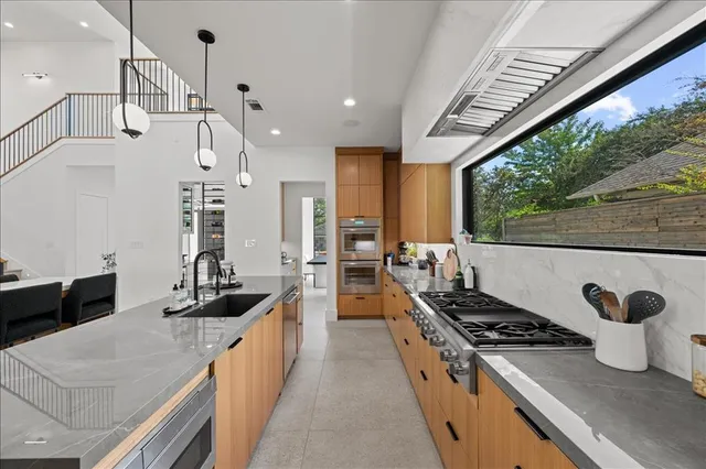 a kitchen with granite countertop a sink and a refrigerator