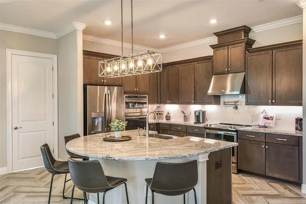 a kitchen with granite countertop a sink and refrigerator