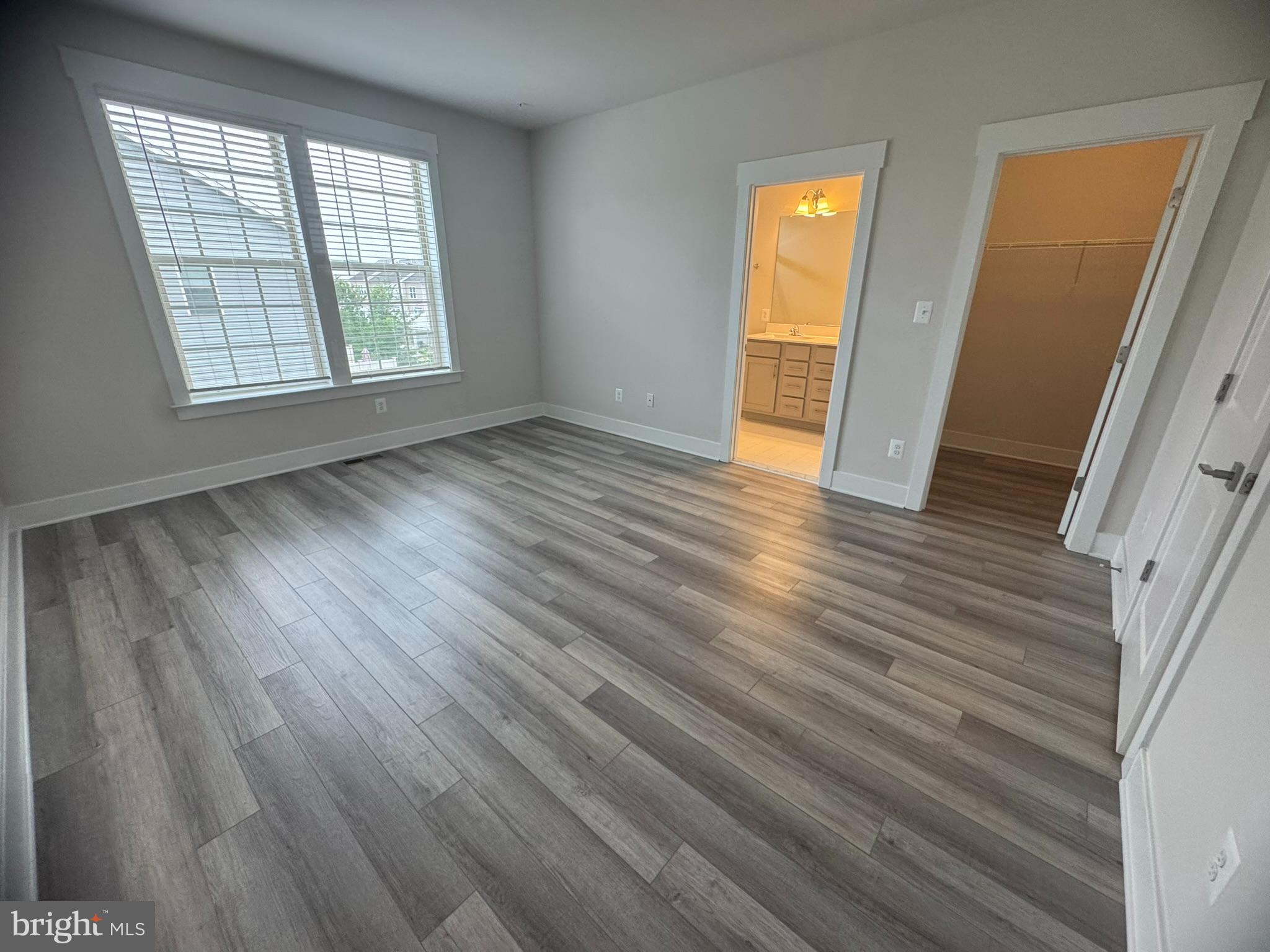 7919 Wormans Mill Road Frederick, MD 21701 - Photo 14 of 23 a view of an empty room with wooden floor and a window