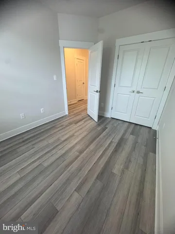 a view of an empty room with closet and a window