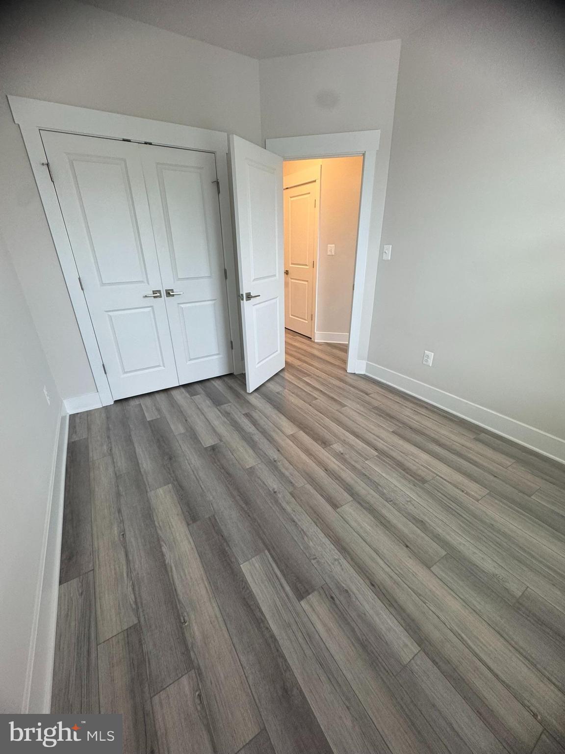 7919 Wormans Mill Road Frederick, MD 21701 - Photo 21 of 23 a view of an empty room with wooden floor and a window