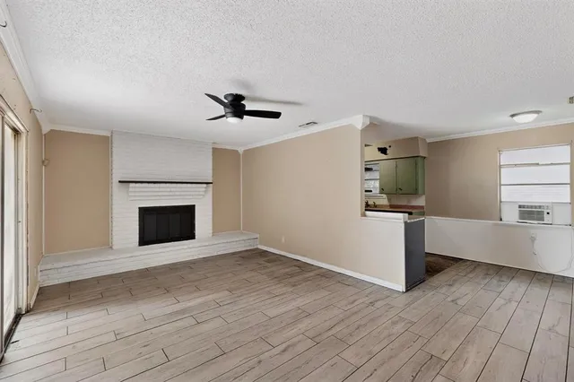 a view of a livingroom with wooden floor and a kitchen