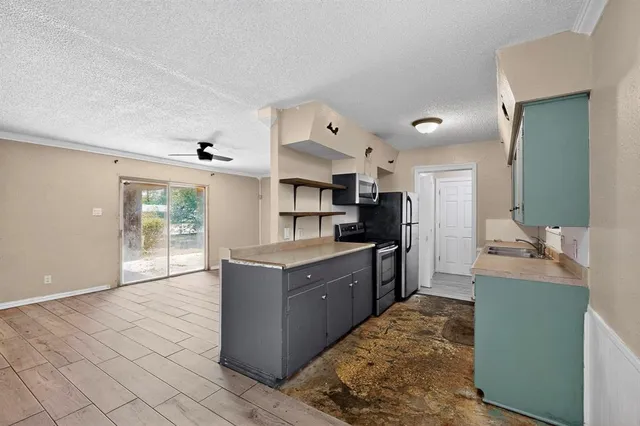 a large kitchen with cabinets and stainless steel appliances