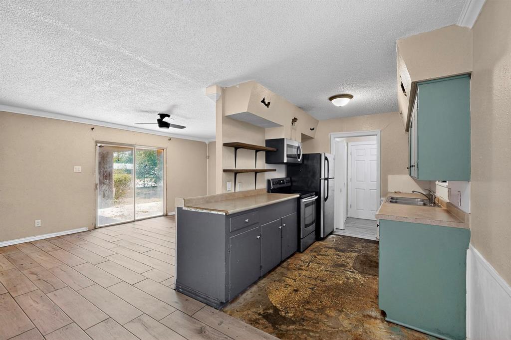 702 Rea Avenue Lancaster, TX 75146 - Photo 12 of 37 a large kitchen with cabinets and stainless steel appliances