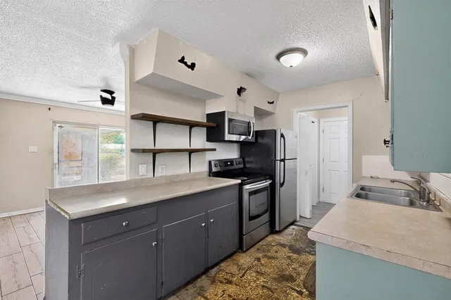 a kitchen with granite countertop a sink stainless steel appliances and cabinets