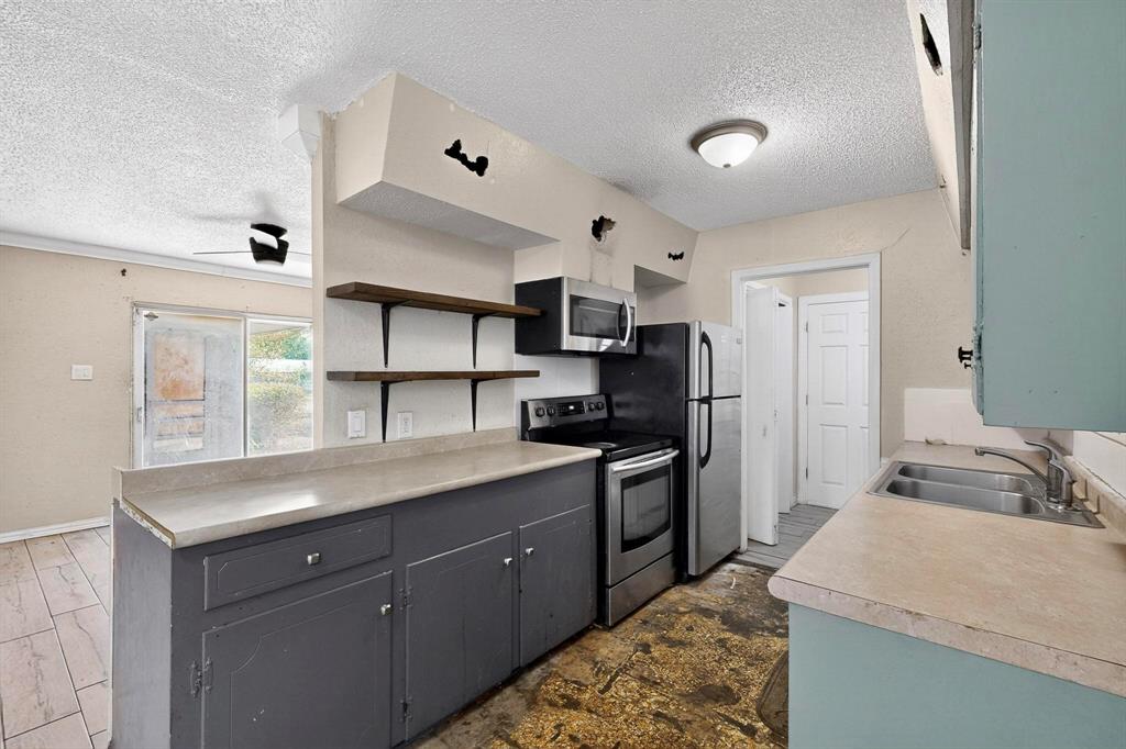 702 Rea Avenue Lancaster, TX 75146 - Photo 14 of 37 a kitchen with granite countertop a sink stainless steel appliances and cabinets