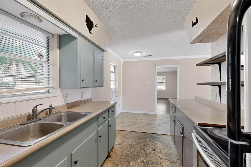 702 Rea Avenue Lancaster, TX 75146 - Photo 15 of 37 a kitchen with a sink and cabinets