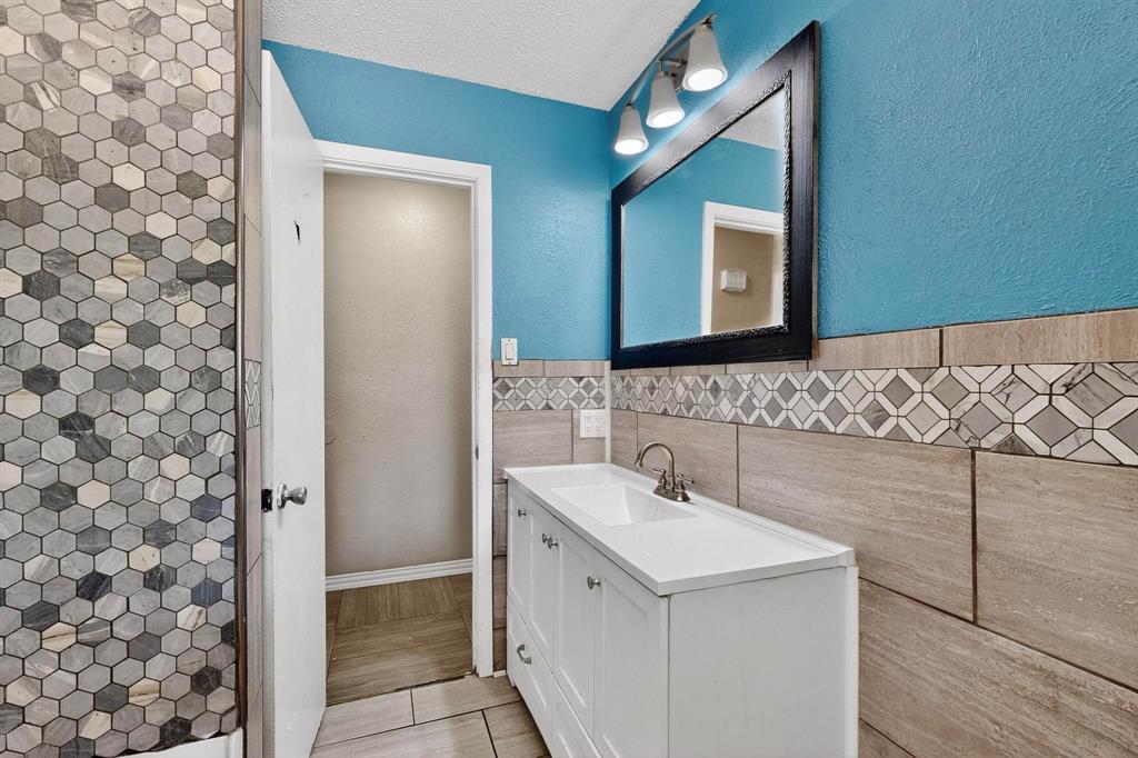 702 Rea Avenue Lancaster, TX 75146 - Photo 24 of 37 a bathroom with a sink and a mirror