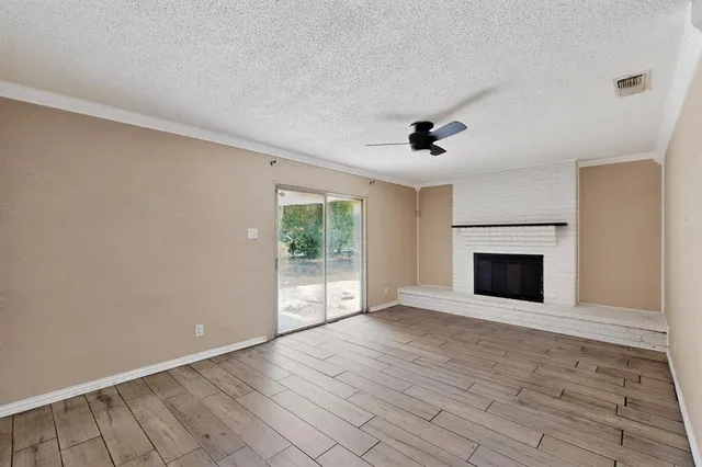 wooden floor fireplace and windows in an empty room