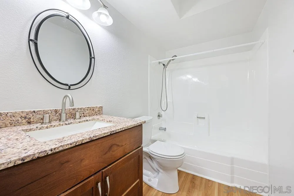 14545 Hillndale Way Poway, CA 92064 - Photo 21 of 27 a bathroom with a granite countertop toilet a sink and a mirror