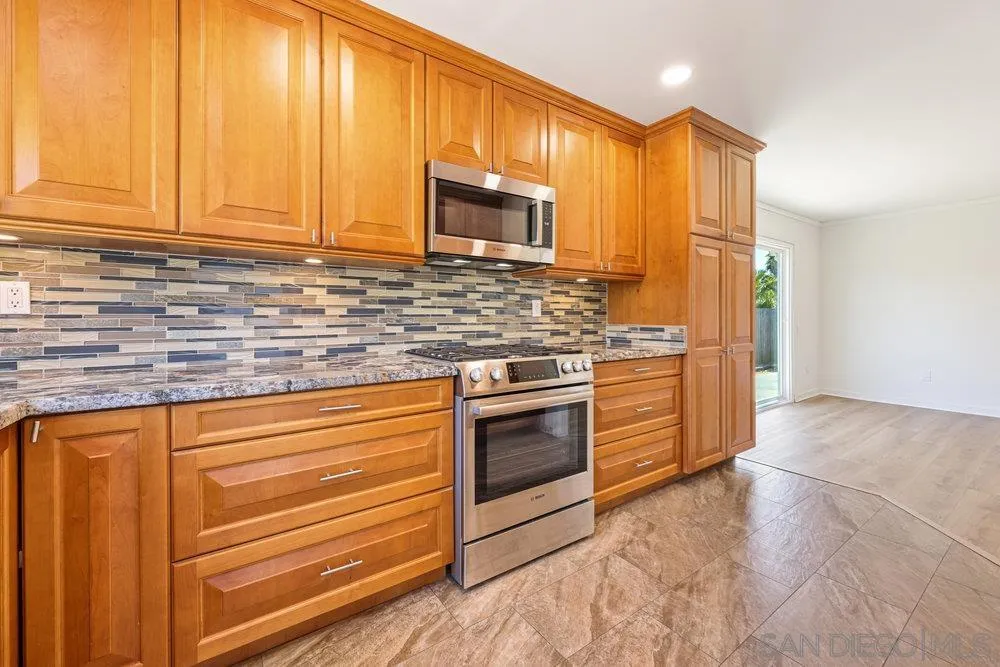 14545 Hillndale Way Poway, CA 92064 - Photo 4 of 27 a kitchen with stainless steel appliances granite countertop a stove a sink and a microwave