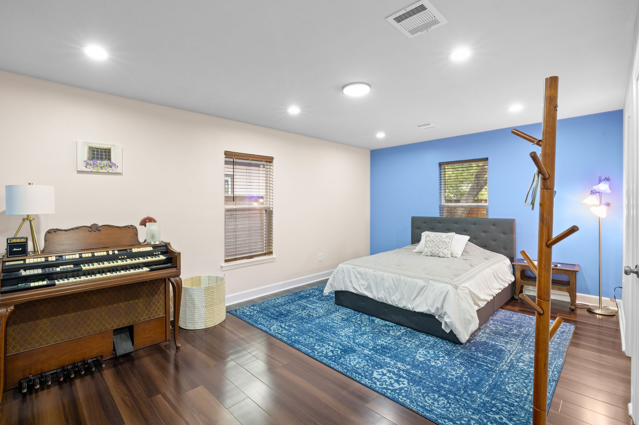 907 East 53rd Street Austin, TX 78751 - Photo 24 of 36 Rich hardwood flooring grounds this well-lit bedroom with ample natural illumination.