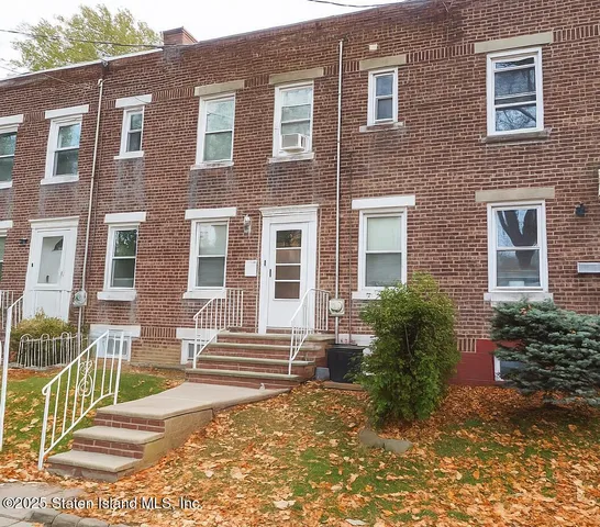 a brick building with a large windows and a yard