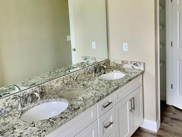 a bathroom with a granite countertop sink and a mirror
