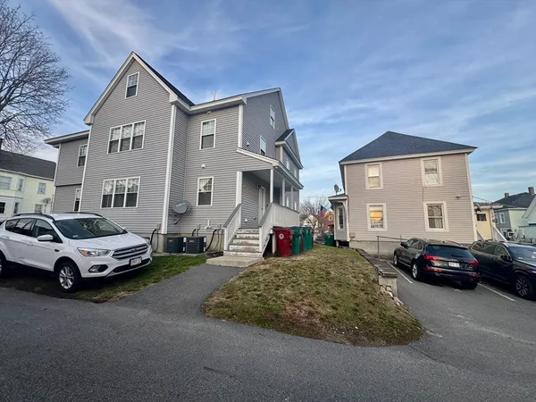 a front view of a house with cars parked