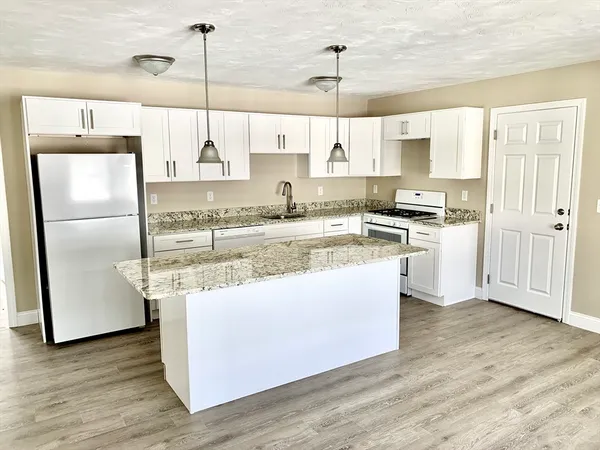 a kitchen with stainless steel appliances granite countertop a sink a stove and a refrigerator