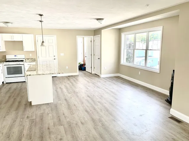 a view of a kitchen with wooden floor and electronic appliances