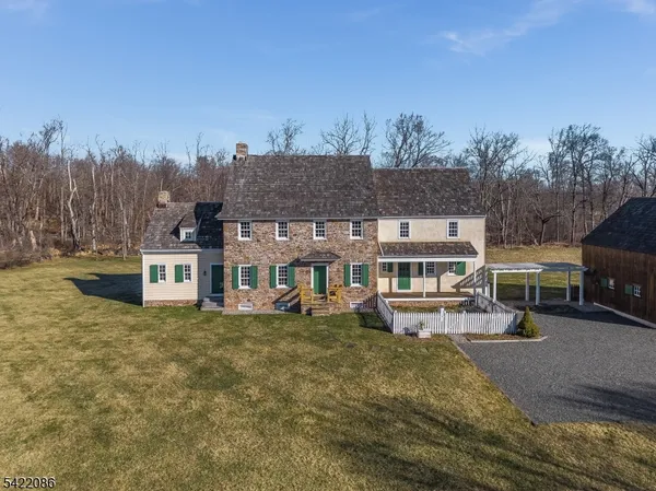 a view of a house with a big yard and large trees