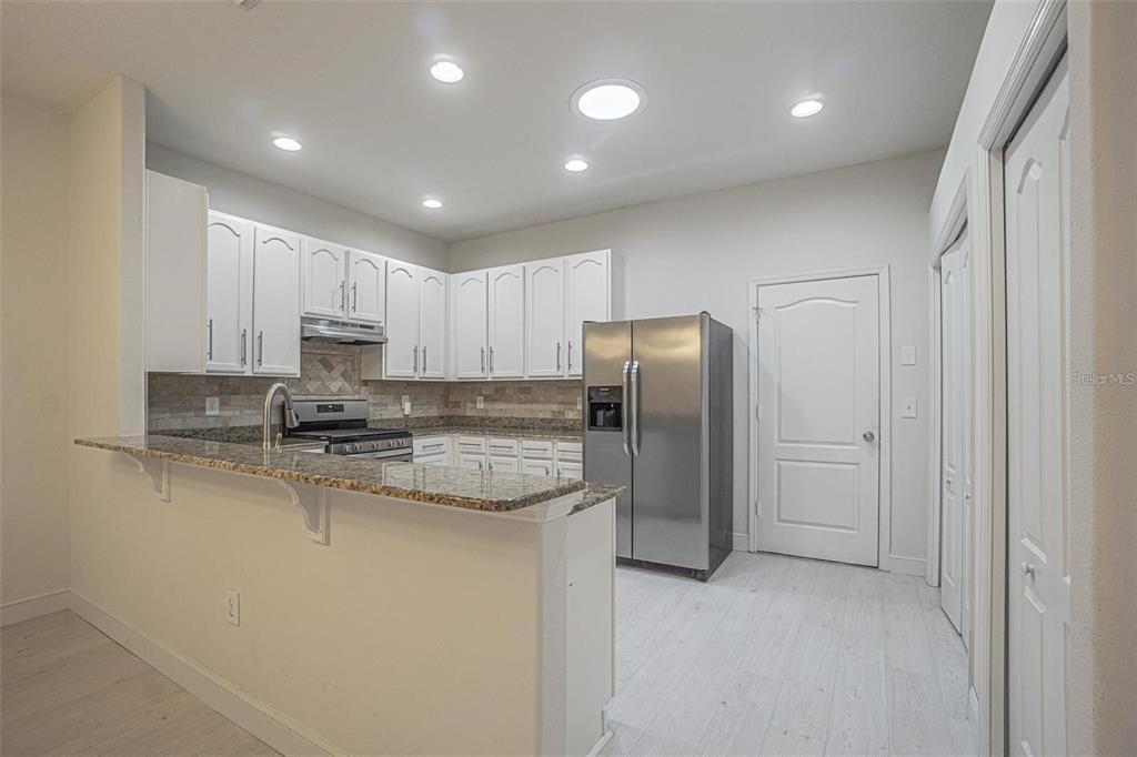 31912 Turkeyhill Drive Wesley Chapel, FL 33543 - Photo 6 of 27 a kitchen with stainless steel appliances granite countertop a refrigerator a stove and a sink