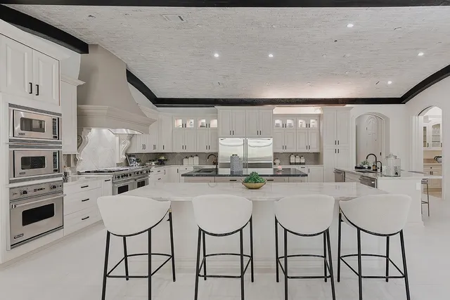 a kitchen with stainless steel appliances kitchen island granite countertop a stove a table and chairs in it