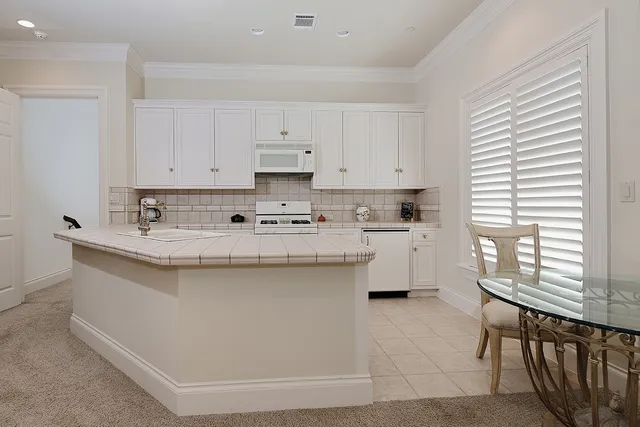 a kitchen with stainless steel appliances granite countertop a sink a stove and a refrigerator