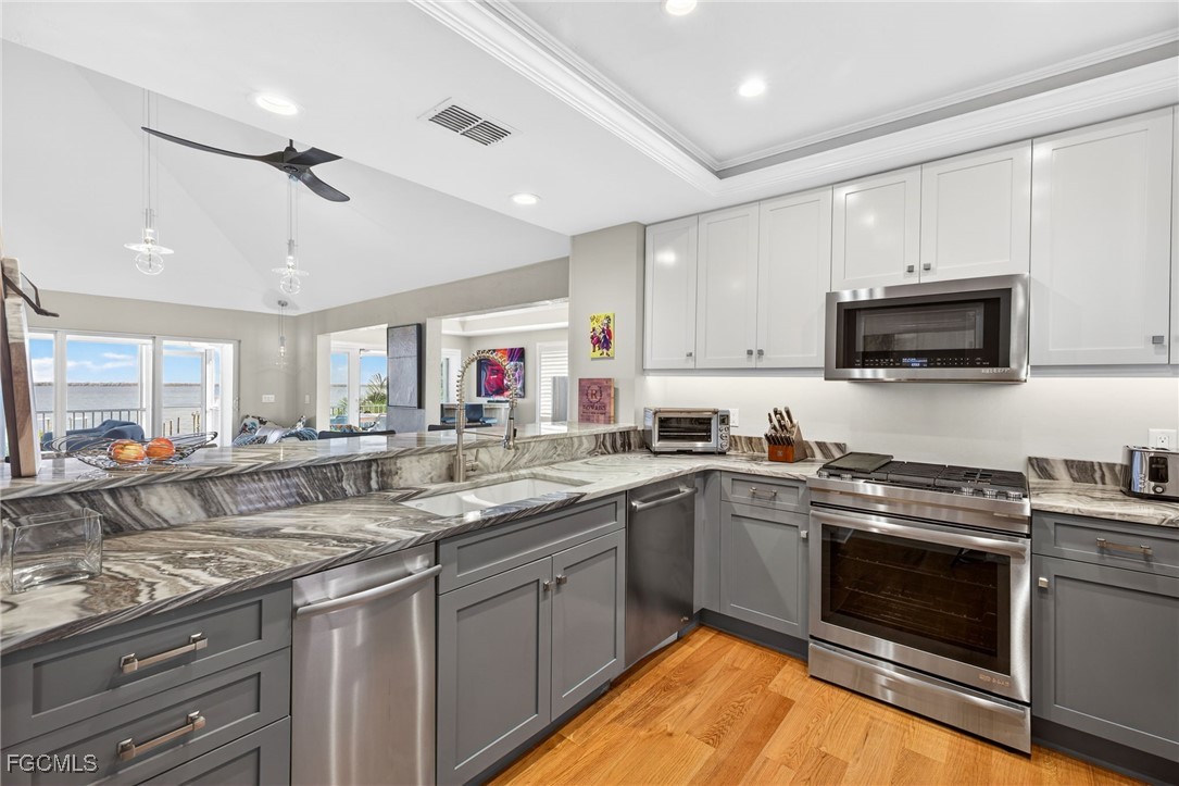 323 Useppa Island Bokeelia, FL 33922 - Photo 14 of 36 a kitchen with stainless steel appliances granite countertop a sink and stove top oven