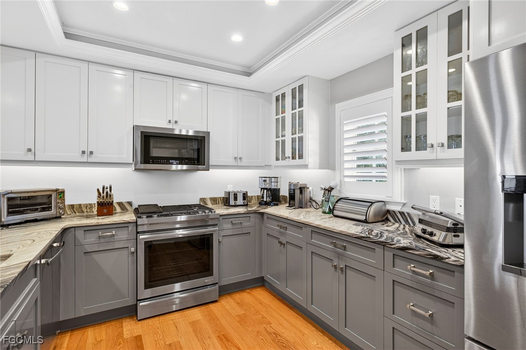 323 Useppa Island Bokeelia, FL 33922 - Photo 15 of 36 a kitchen with stainless steel appliances granite countertop a sink a stove a microwave a refrigerator and cabinets