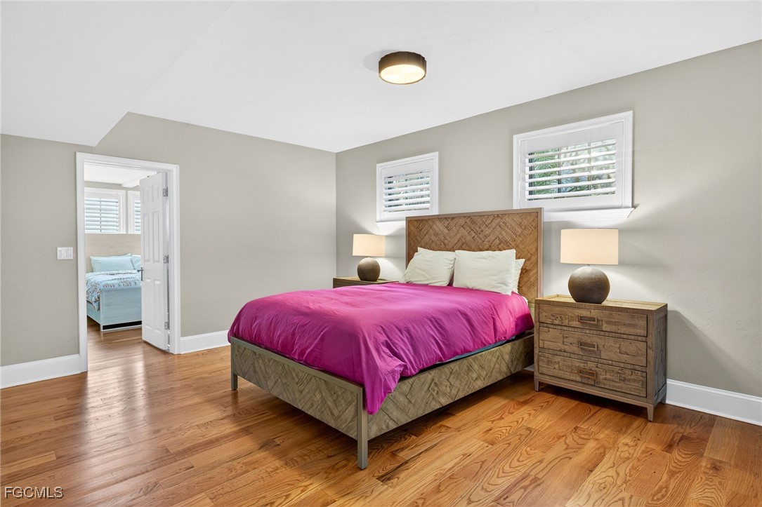 323 Useppa Island Bokeelia, FL 33922 - Photo 21 of 36 a bedroom with a bed and wooden floor