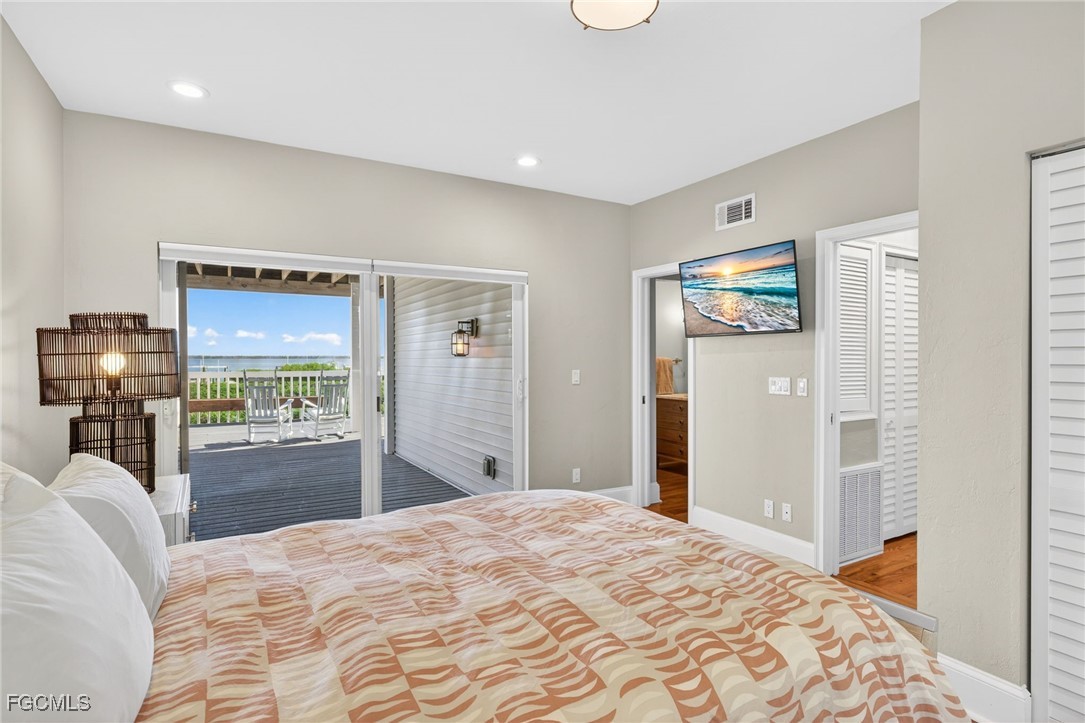 323 Useppa Island Bokeelia, FL 33922 - Photo 23 of 36 a bedroom with a bed and a flat screen tv