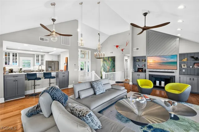 a living room with furniture kitchen view and a chandelier