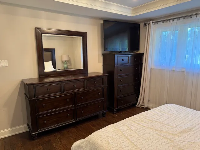 a bedroom with a bed and a mirror on dresser