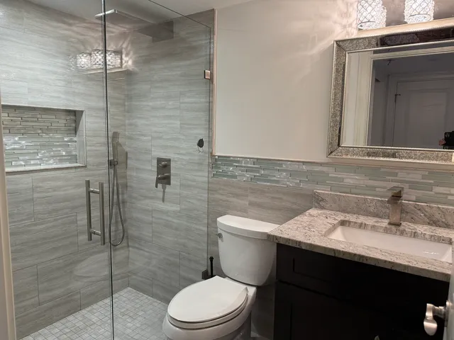 a bathroom with a sink a toilet and shower