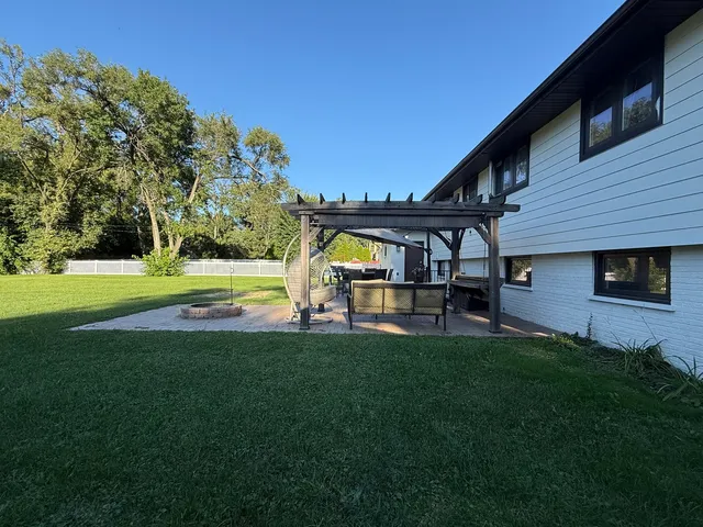 a view of house with swimming pool and yard