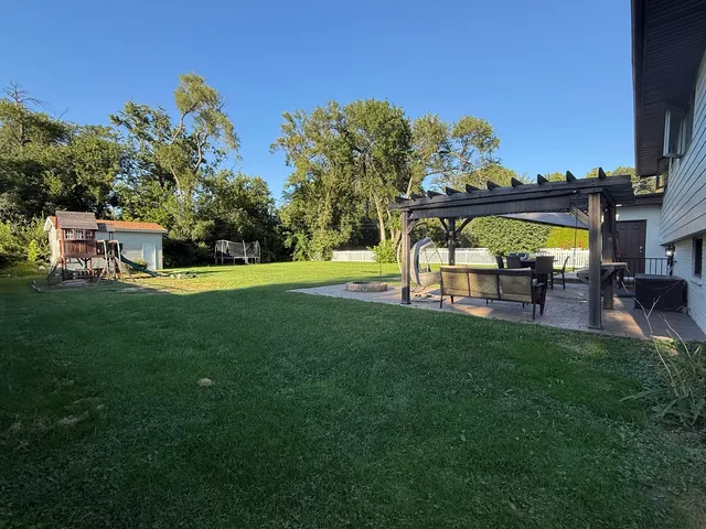 a view of a chair and table on the green field