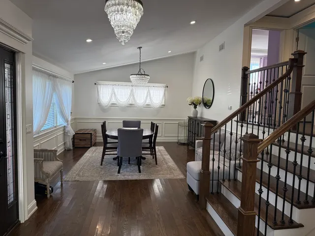 a view of a dining room with furniture a chandelier and wooden floor