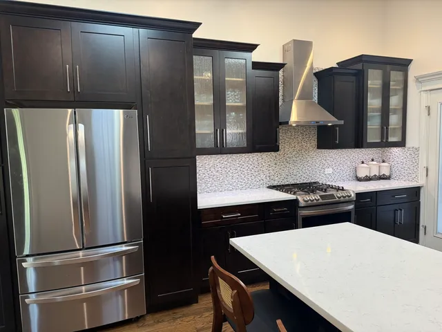 a kitchen with stainless steel appliances a refrigerator and a stove top oven