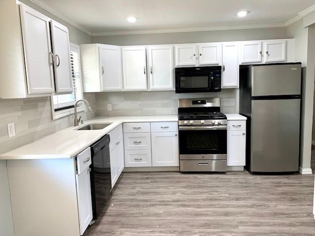 768 Pine Street Hurst, TX 76053 - Photo 3 of 11 Kitchen with black appliances, crown molding, white cabinetry, decorative backsplash, and recessed lighting