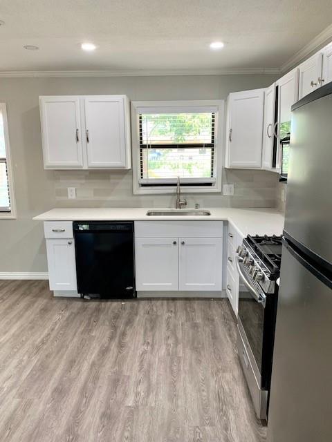 768 Pine Street Hurst, TX 76053 - Photo 4 of 11 Kitchen with crown molding, white cabinets, appliances with stainless steel finishes, plenty of natural light, and decorative backsplash