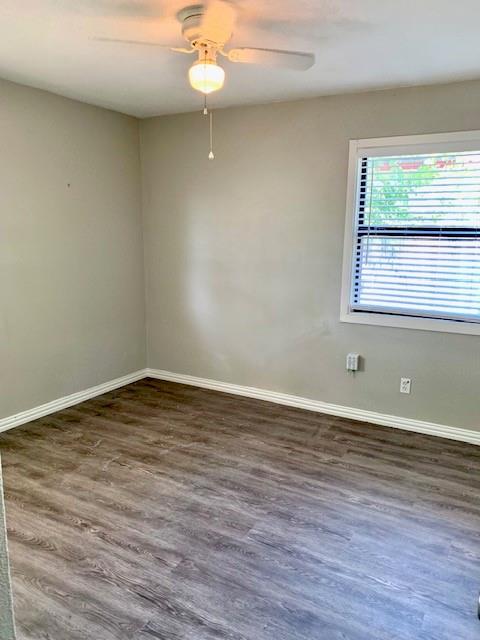 768 Pine Street Hurst, TX 76053 - Photo 5 of 11 Empty room featuring dark wood finished floors and a ceiling fan