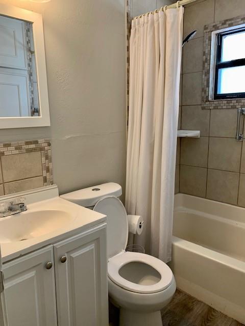 768 Pine Street Hurst, TX 76053 - Photo 9 of 11 Bathroom with shower / bath combo with shower curtain, decorative backsplash, vanity, and a textured wall