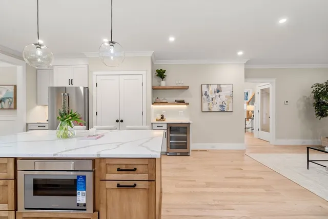 a kitchen with stainless steel appliances granite countertop a stove a refrigerator and a oven with wooden floor