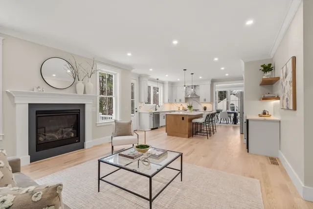 a living room with furniture a fireplace and kitchen view