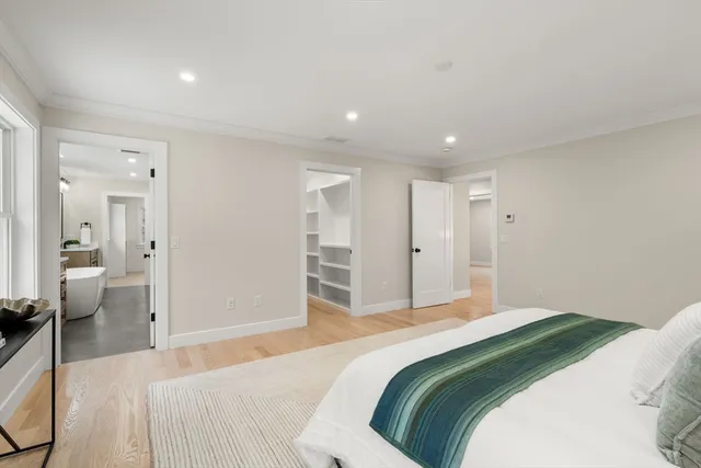 a bedroom with a large bed and chandelier