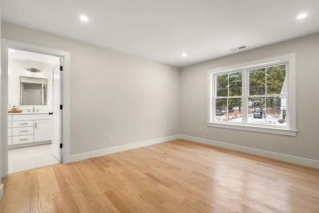 an empty room with windows and cabinet