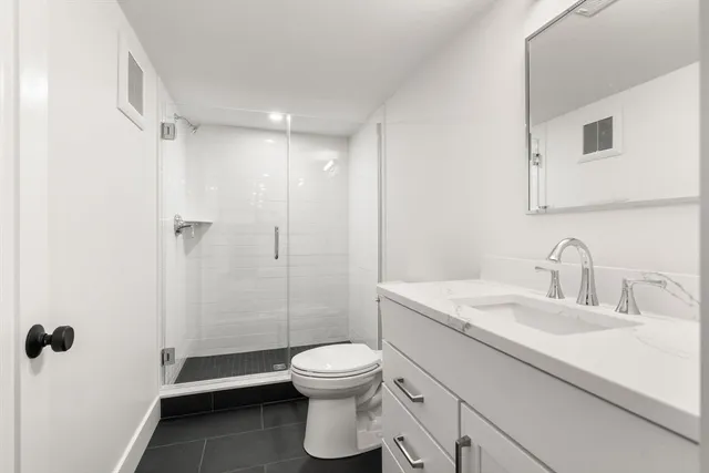 a bathroom with a toilet sink a shower and a mirror