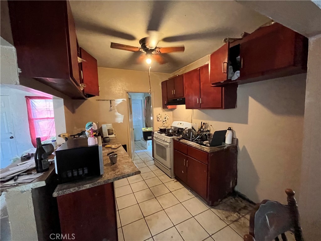 45639 King Street Indio, CA 92201 - Photo 8 of 28 a kitchen with stainless steel appliances granite countertop a stove top oven a sink dishwasher and a refrigerator with wooden cabinets