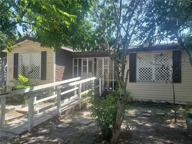 a front view of a house with a tree